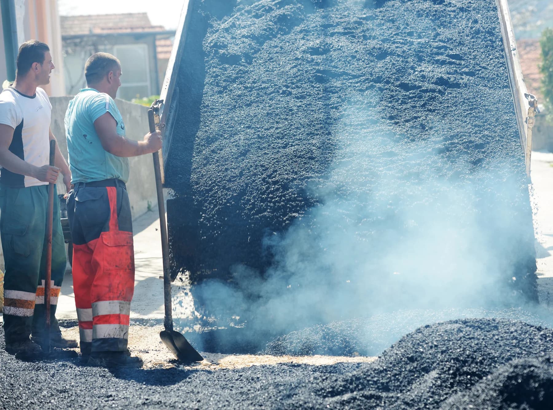 Asphalt crew working beside hot-mix pavement