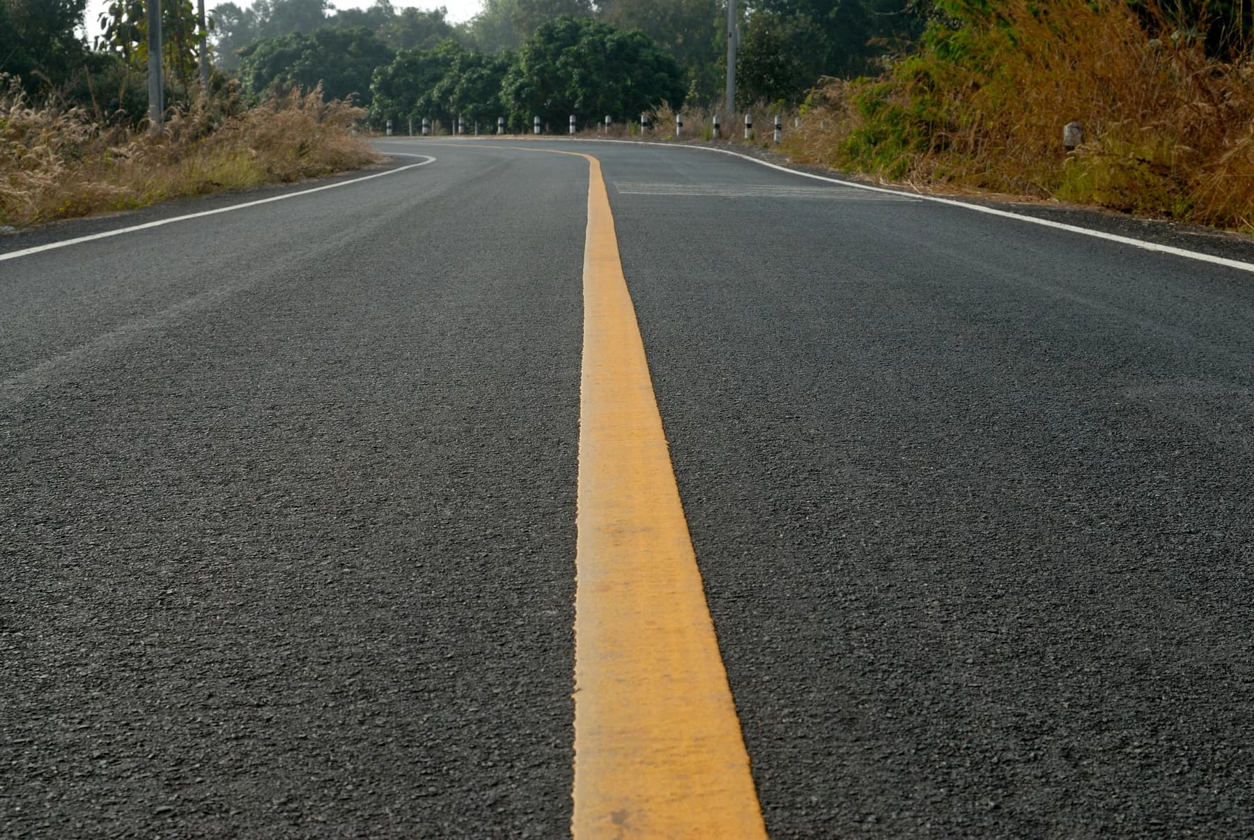 Dark asphalt roadway with a yellow centerline